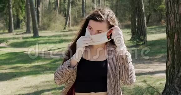 针叶林中戴防护面具的年轻女子肖像保护covid19冠状病毒病毒大流行视频的预览图