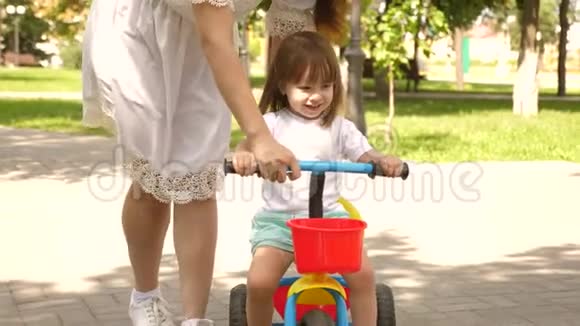 快乐妈妈教小女儿骑自行车妈妈在户外和孩子玩孩子学会骑自行车视频的预览图