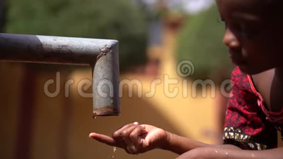 非洲女孩数着干涸的水泵站的水滴视频的预览图