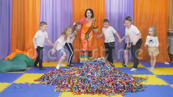 五彩的彩带向不同的方向飞舞孩子们跑到一堆彩纸上视频的预览图