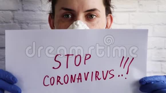 一个戴着防护面罩的女人的肖像上面的镜头是用白色的纸上写着停止冠状病毒视频的预览图
