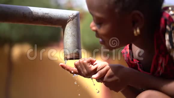 非洲一个农村的非洲女孩在水泵站握着手指视频的预览图