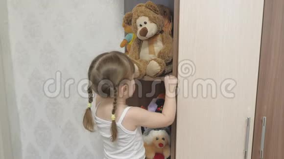 这孩子喜欢玩他的玩具小快乐女孩积极玩毛绒玩具和泰迪熊这孩子在玩视频的预览图