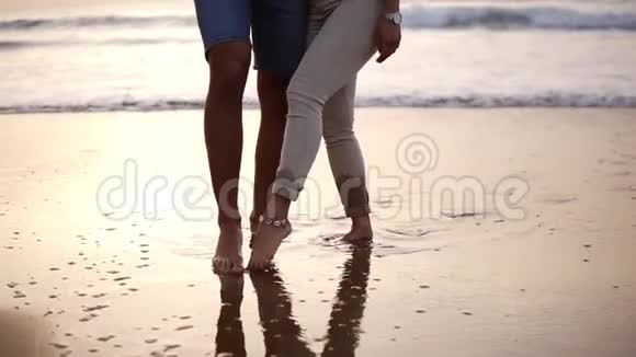 一对情侣一男一女用脚在湿沙的心上画画关于海上情侣的录像视频的预览图