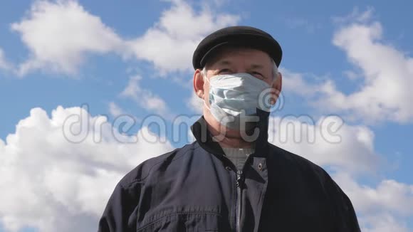 一个戴着医疗面具的老人流行性冠状病毒男人在街上戴着保护面具保健视频的预览图
