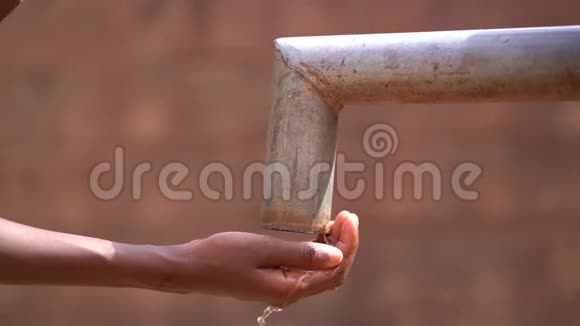 关上一个女孩的手伸手去村里的泵站取水视频的预览图