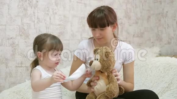 健康儿童在医院玩耍被隔离的小女孩在玩具熊上戴上医疗面具保护视频的预览图