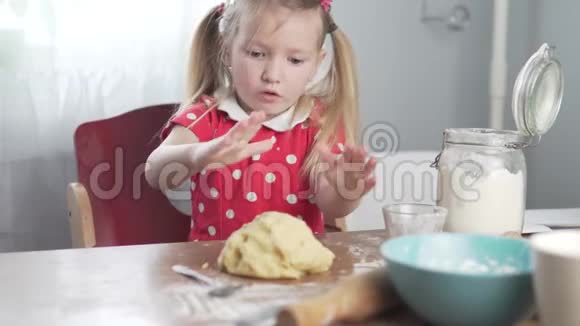 一个小女孩在厨房里揉面团当馅饼视频的预览图