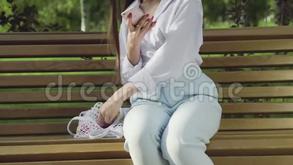 在夏季公园里年轻女子坐在长椅上手里拿着全是水果和蔬菜的棉网购物袋视频的预览图