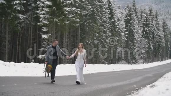 一对夫妇在森林里的路上散步视频的预览图