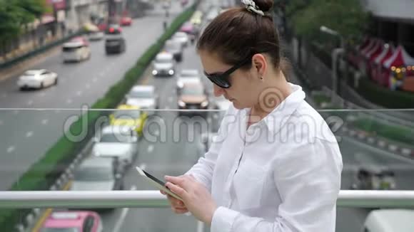 布吕内特的白色类型的智能手机桥上街道视频的预览图