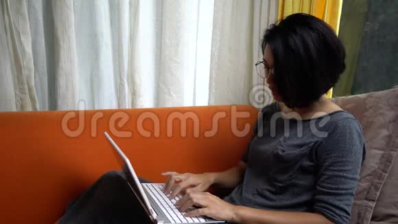 快乐的女人在家里电脑学习视频的预览图
