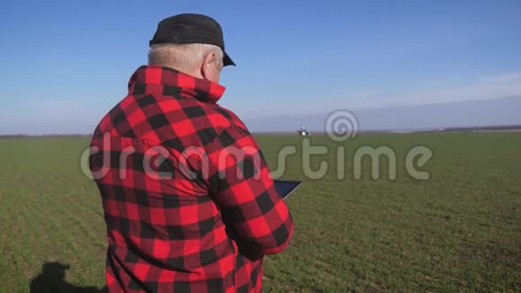 一个成熟的农民在冬天后看着一片新鲜的绿色田野他制定了收割和播种的计划视频的预览图