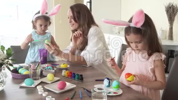准备复活节的幸福家庭母亲带着女儿画鸡蛋视频的预览图