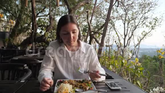 布鲁内特女士在山上的一家咖啡馆吃面条和蔬菜视频的预览图