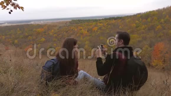 免费游客男人和女人带着自拍背包在一座美丽的小山上健康的旅行者通过电话拍照视频的预览图