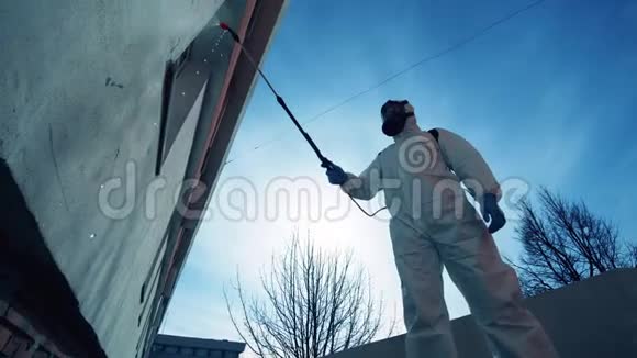 穿防护服的工人对建筑物进行消毒视频的预览图