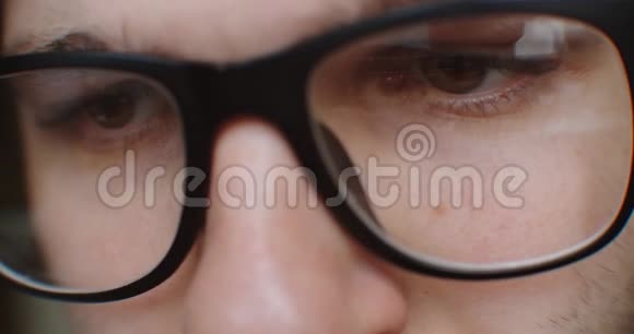 戴眼镜的人在网上搜索特写镜头眼睛观察显示视频的预览图