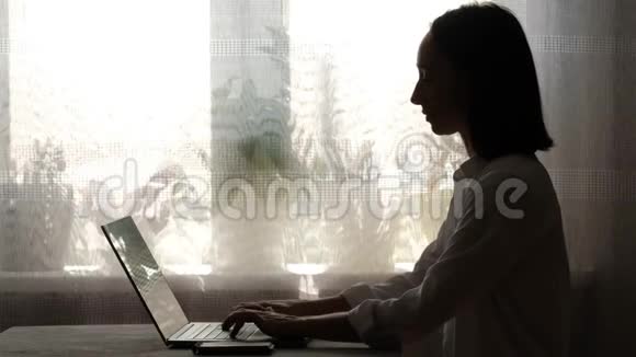 在家工作的女孩在笔记本电脑上打印视频的预览图