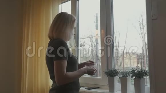 站在窗前的女人戴着医用防护面罩视频的预览图