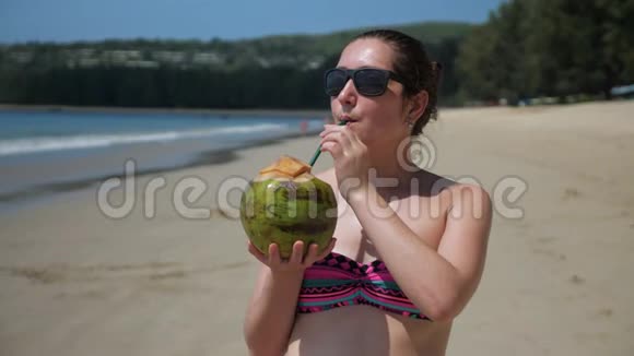 女人用吸管喝椰子汁享受假期视频的预览图