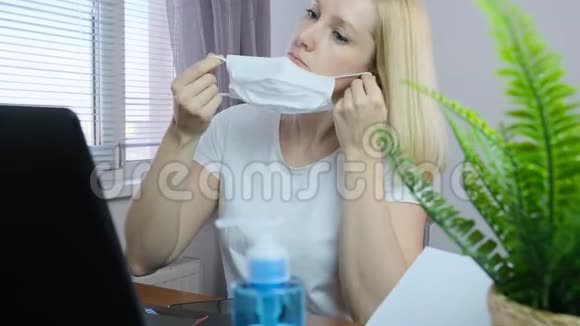 欧洲白种人商业女性自由职业者戴上白色外科防护面罩在隔离期间远程工作视频的预览图