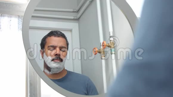 在镜子后面的人在他早晨的面部护理过程中视频的预览图