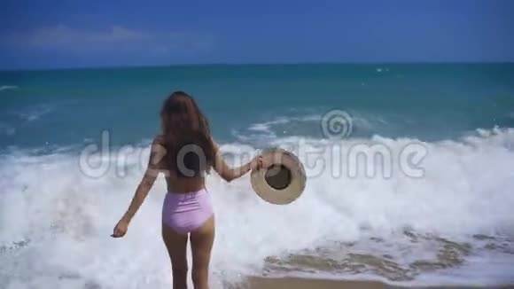 美丽的女孩走在沙滩上一个戴太阳镜和粉红色泳衣的女孩拉麦海滩度假视频的预览图