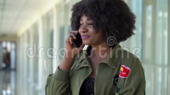 非裔美国女孩正在机场等待登机和离境并在电话中交谈视频的预览图