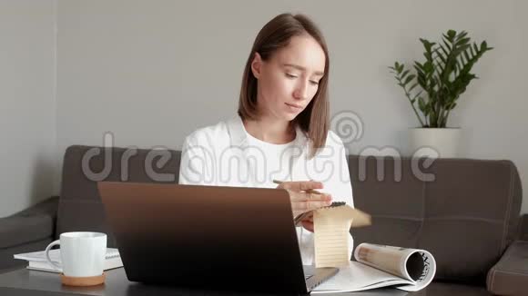 女孩在家工作翻着笔记本视频的预览图