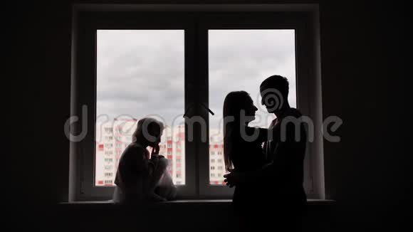 新公寓窗户背景上有孩子的恋人剪影视频的预览图
