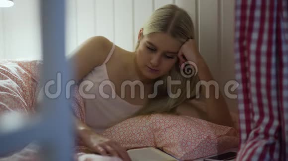 年轻女子在舒适的客厅看书视频的预览图