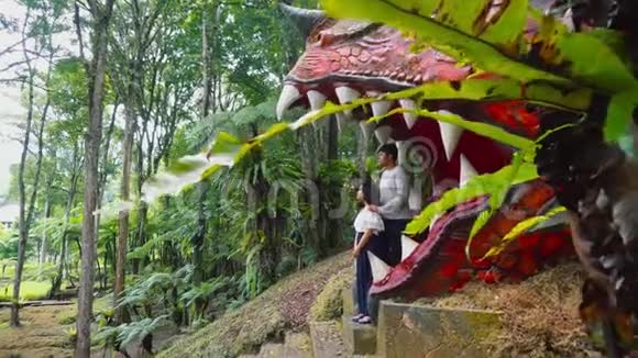 可爱的亚洲夫妇摆在巨大的奇妙的雕塑下巴一起度假视频的预览图