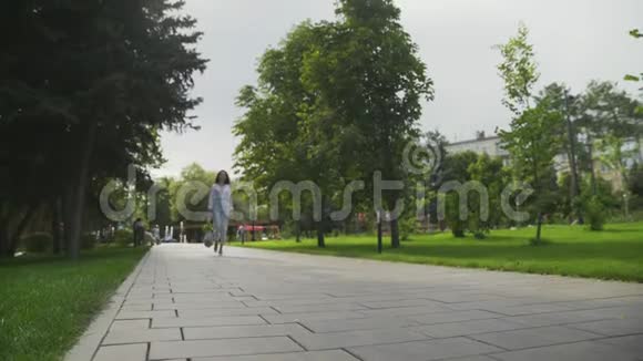 女人拿着带蔬菜的棉网购物袋在夏季公园散步零浪费购物视频的预览图