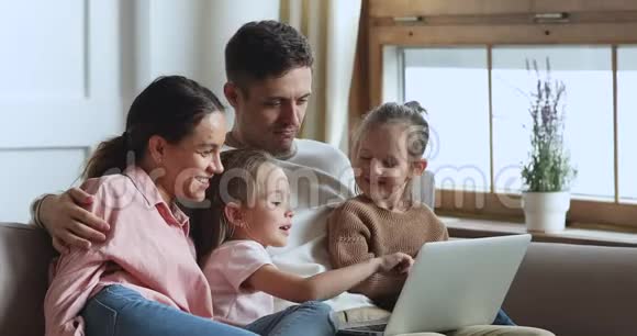 女孩与姐姐和父母一起在电脑上使用教育应用程序视频的预览图