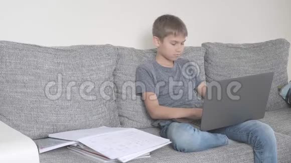 普雷特恩男孩用笔记本电脑学习在家做作业技术教育在线学习视频的预览图