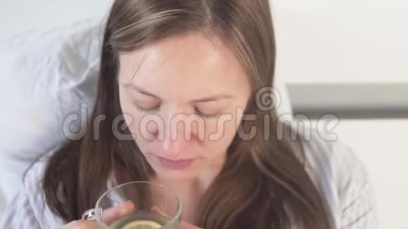 女人在家里的床上喝柠檬茶视频的预览图