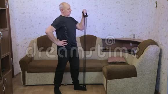 一个在客厅训练的男人用扩张器做伸展运动视频的预览图