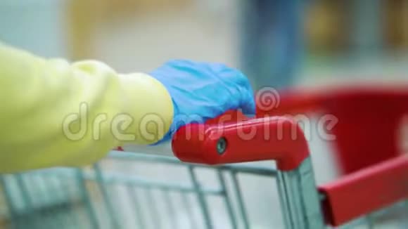 女性手戴医用手套推超市购物车视频的预览图