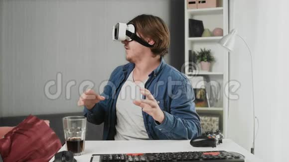 在家中使用现代虚拟现实眼镜的年轻人视频的预览图
