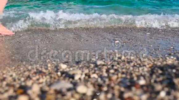 女孩在水波上行走苗条的女性腿在海滨移动泼水视频的预览图