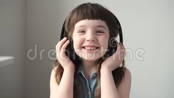 戴着大无线耳机的女孩听着笑着快关门视频的预览图