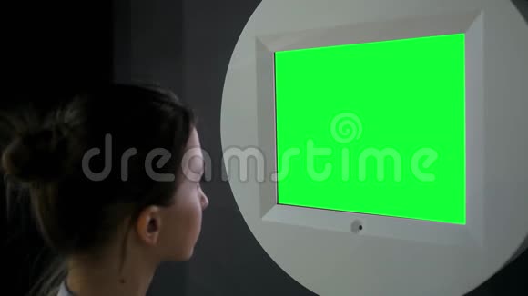 在展览中看到空白绿色展示墙的女人绿色屏幕概念视频的预览图