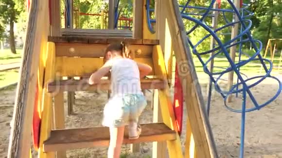 快乐的童年概念孩子爬上楼梯孩子们滑倒妈妈和宝宝在操场上玩开心快乐视频的预览图