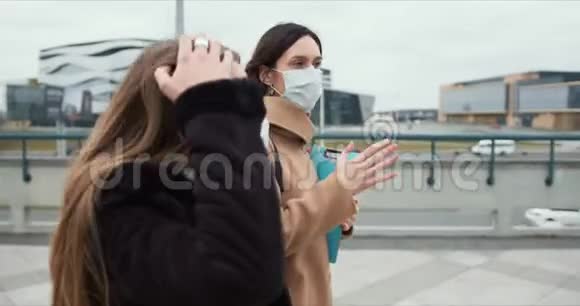 COVID19流行病保健工作者两名白人女医生戴着医用口罩在空城街道上散步视频的预览图