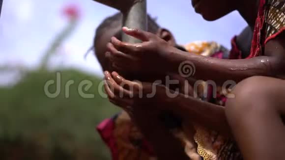 两个非洲小女孩在村里的水泵旁提神视频的预览图