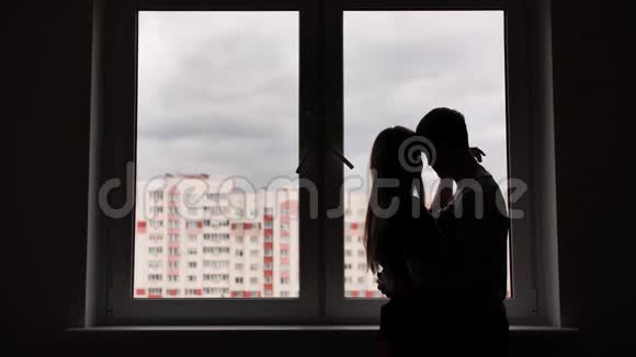 新公寓窗户背景上有孩子的恋人剪影视频的预览图