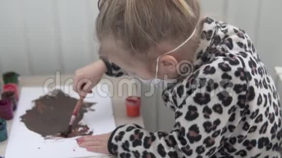 一个戴着医用口罩的小女孩在家里画画视频的预览图