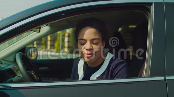 微笑的黑人女人从车窗向外看视频的预览图