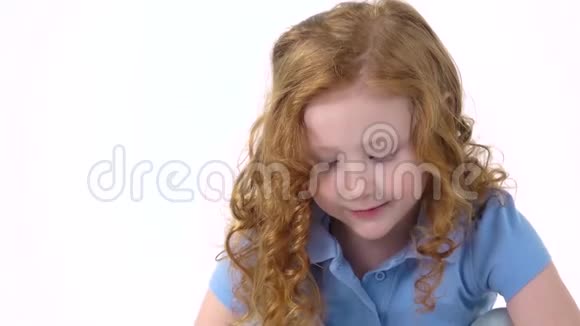 红头发的小女孩卷曲的头发正在抚摸蓬松的三色兔子在白色的背景慢动作关门视频的预览图